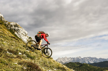 Österreich, Altenmarkt-Zauchensee, junger Mountainbiker beim Fahren in den Niederen Tauern - HHF005281