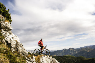 Österreich, Altenmarkt-Zauchensee, junger Mountainbiker beim Blick auf die Niederen Tauern - HHF005293