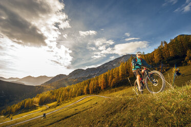 Österreich, Altenmarkt-Zauchensee, junger Mountainbiker beim Fahren in den Niederen Tauern - HHF005295