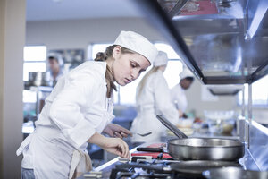 Teenage girl cooking in canteen kitchen - ZEF005948