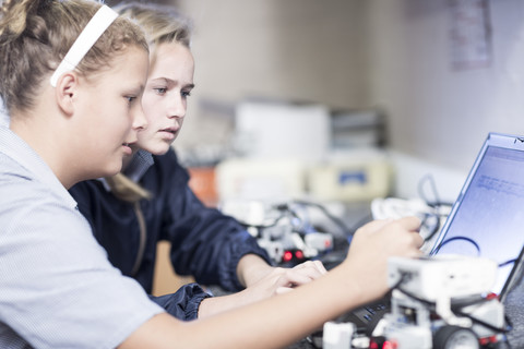 Two schoolgirls with laptop in robotics class stock photo