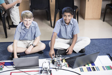 Zwei lächelnde Schüler mit Laptops im Robotikunterricht - ZEF006111