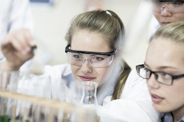 Students in chemistry class pipetting liquid into test tube - ZEF006134