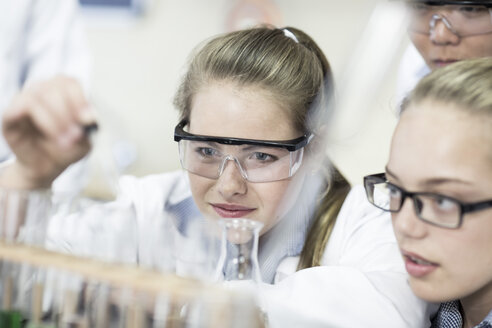 Schüler im Chemieunterricht pipettieren Flüssigkeit in ein Reagenzglas - ZEF006134