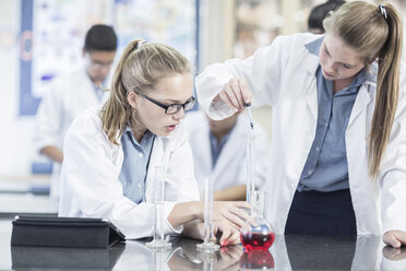 Two schoolgirls in chemistry class working with liquids - ZEF006140