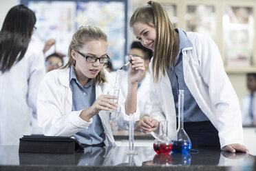 Two schoolgirls in chemistry class working with liquids - ZEF006141