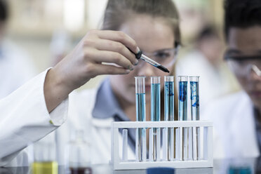 Students in chemistry class pipetting liquid into test tube - ZEF006122