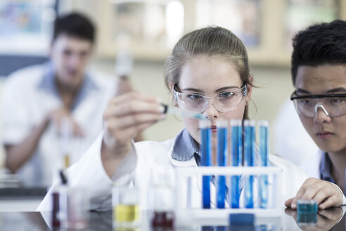 Schüler im Chemieunterricht pipettieren Flüssigkeit in ein Reagenzglas - ZEF006124