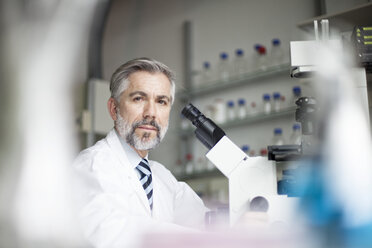 Portrait of scientist in laboratory with microscope - RBF002527