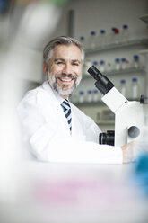 Portrait of smiling scientist in laboratory with microscope - RBF002529