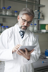 Scientist using digital tablet in laboratory - RBF002542