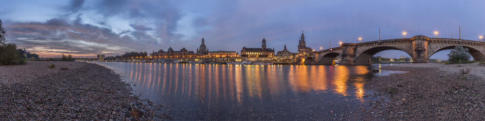 Deutschland, Dresden, Blick auf beleuchtete Altstadt mit Elbufer im Vordergrund in der Morgendämmerung - PVC000316