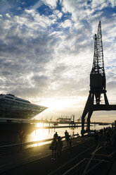 Deutschland, Hamburg, Menschen an der Elbe und Bürogebäude Dockland bei Sonnenuntergang - KRPF001363