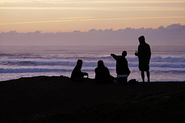 Portugal, Algarve, Sagres, Cordoama Beach, Silhouette von vier Personen in der Abenddämmerung - MR001563