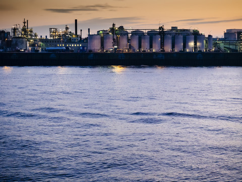 Deutschland, Hamburg, Hafen, Industrieanlage an der Elbe bei Nacht, lizenzfreies Stockfoto