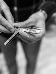 Hairdresser's hand holding razor - MGOF000146