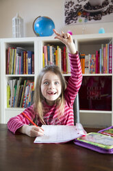 Girl doing homework raising her arm - SARF001564