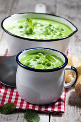 Saucepan and mug of pea soup on cloth - CSF024973