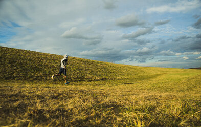 Germany, Mannheim, young man jogging in meadow - UUF003628