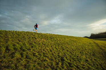 Deutschland, Mannheim, junger Mann joggt auf einer Wiese - UUF003647