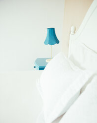 Indonesien, Bali, Tischlampe auf blauem Nachttisch und Bett im Schlafzimmer einer Ferienvilla - MBEF001347