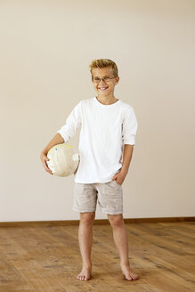 Lächelnder Junge mit Fußball zu Hause - LBF001096