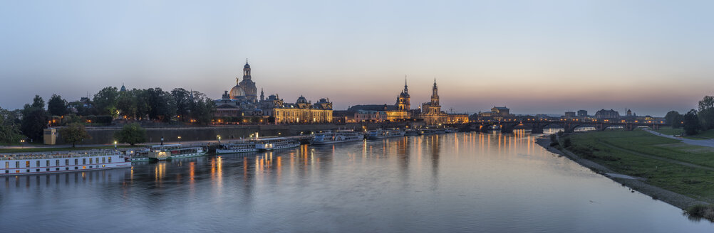 Deutschland, Dresden, Blick auf die beleuchtete Stadt mit der Elbe im Vordergrund am Abend - PVCF000348