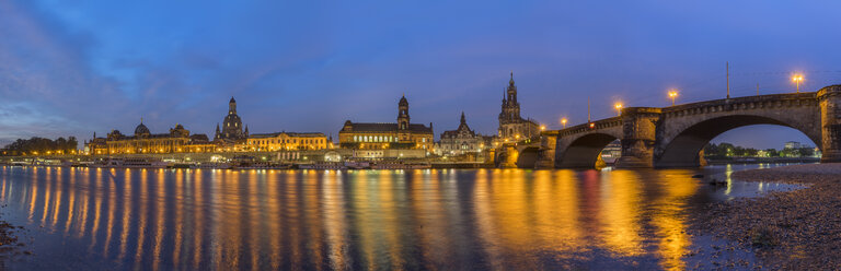 Deutschland, Dresden, Blick auf die beleuchtete Stadt mit der Elbe im Vordergrund am Morgen - PVCF000349