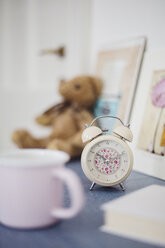 Wecker mit Blumenmuster auf dem Nachttisch im Zimmer eines Mädchens - LSF000009