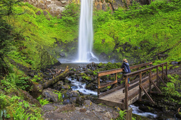 USA, Oregon, Multnomah County, Columbia River Gorge, Elowah Falls, Weibliche Touristin steht auf Brücke - FOF007906