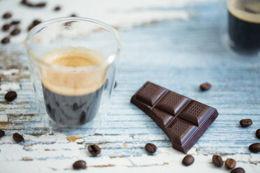 Glastasse mit Espresso, gerösteten Kaffeebohnen und dunkler Schokolade auf Holz - LSF000010