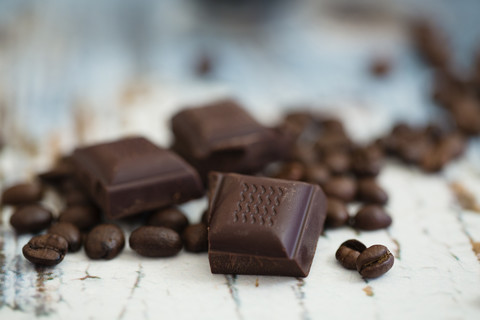 Roasted coffee beans and pieces of dark chocolate on wood stock photo