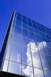 Germany, Bielefeld, glass facade of a commercial house with reflection of cloud - HOHF001306