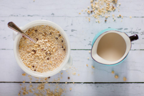 Schale mit Quinoa-Frühstücksflocken und Milchkännchen, lizenzfreies Stockfoto