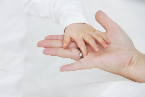 Baby girl's hand on mother's hand - JTLF000090