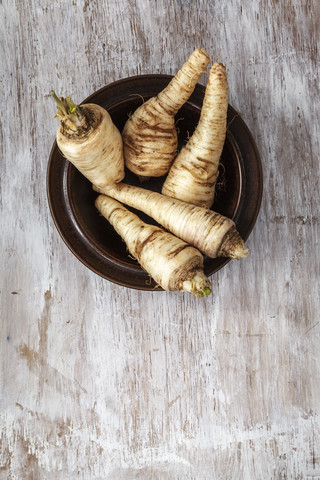 Bowl of parsley roots on wood stock photo