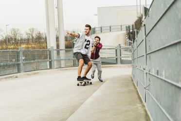 Zwei Freunde fahren mit dem Skateboard - UUF003670