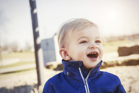 Deutschland, Oberhausen, Kleinkind mit offenem Mund auf Spielplatz, lizenzfreies Stockfoto