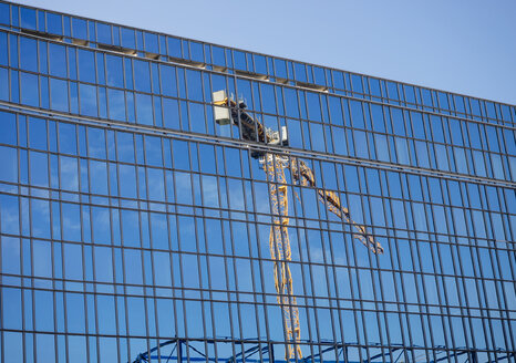 Deutschland, Hamburg, Glasfassade mit Spiegelung eines Baukrans - KRPF001391