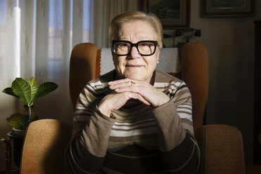 Porträt einer glücklichen älteren Dame, die auf einem Sessel sitzt - GEMF000137