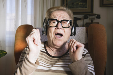 Portrait of happy elderly lady hearing music with headphones - GEMF000138