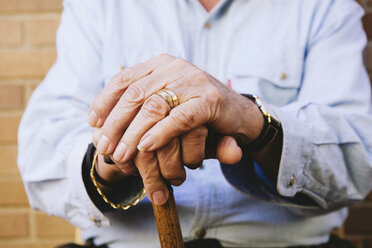 Close-up of old man's hands resting on a cane stock photo