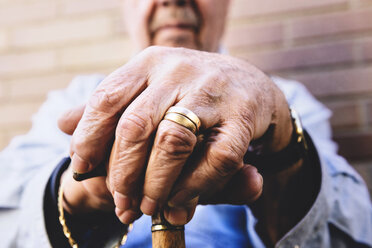 Close-up of old man's hands resting on a cane - GEMF000143