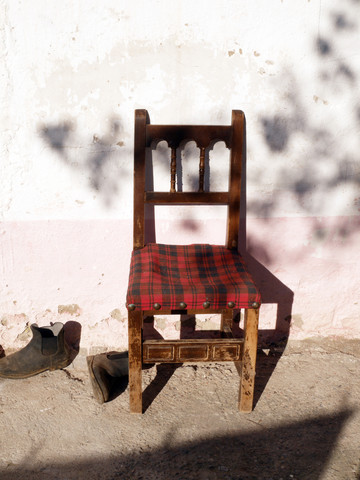 Spanien, Katalonien, Stuhl in Stiefeln bei Sonnenlicht, lizenzfreies Stockfoto