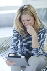 Smiling blond woman with digital tablet - MAEF010008