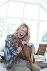 Woman playing with her dog at home - MAEF010015