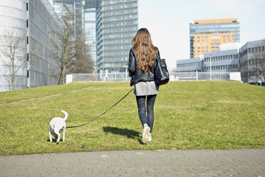 Deutschland, Düsseldorf, Junge Frau geht mit ihrem Hund spazieren - RHF000652