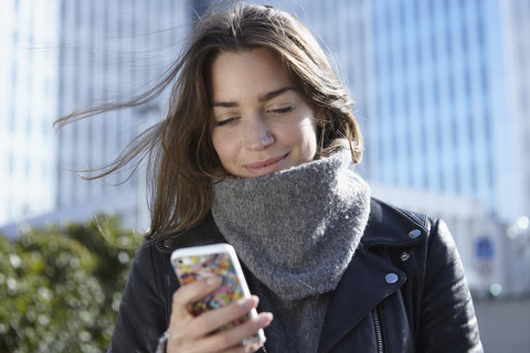 Deutschland, Dusseldorf, Junge Frau hält Smartphone, lizenzfreies Stockfoto