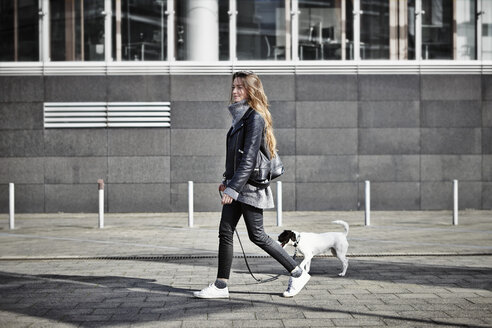 Deutschland, Düsseldorf, Junge Frau geht mit ihrem Hund spazieren - RHF000663