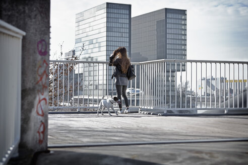 Deutschland, Düsseldorf, Junge Frau geht mit ihrem Hund spazieren - RHF000669